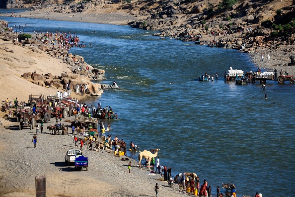 -Des réfugiés éthiopiens ont fui les combats dans la région du Tigré se rassemblent sur les rives d'un fleuve frontalier avec le Soudan, le 22 novembre 2020. Photo par Ashraf Shazly / AFP via Getty Images.