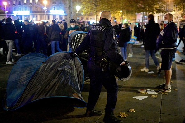 Les gendarmes français évacuent un camp de fortune monté par des migrants, des fonctionnaires et des volontaires d'ONG sur la place de la République à Paris le 23 novembre 2020 (MARTIN BUREAU/AFP via Getty Images)