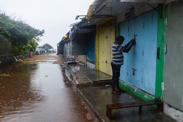 -Un commerçant ferme sa boutique alors que le cyclone Nivar s'approche de la côte est de l'Inde, à Mahabalipuram, le 24 novembre 2020. Photo par Arun Sankar/ AFP via Getty Images.