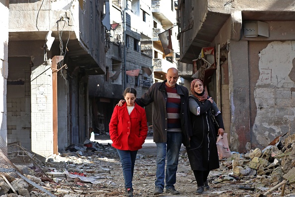 -Issa al-Loubani, un réfugié palestinien de 48 ans, se promène avec sa femme et sa fille dans une rue du camp palestinien de Yarmuk, à la périphérie sud de la capitale syrienne Damas, le 25 novembre 2020. Photo par Louai Beshara / AFP via Getty Images. 