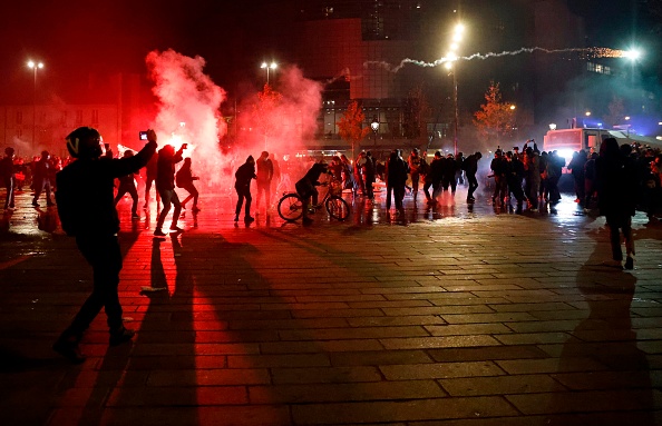 Des manifestants lancent un feu d'artifice (à droite) pour faire feu sur des policiers anti-émeutes lors d'une manifestation contre le projet de loi sur la « sécurité mondiale », à Paris, le 28 novembre 2020 - (THOMAS COEX/AFP via Getty Images)