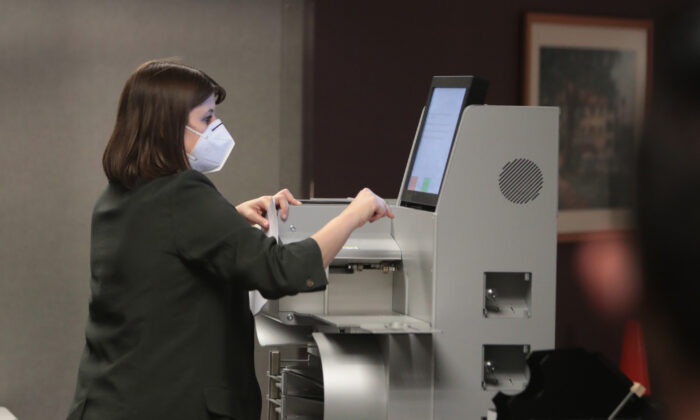 Une fonctionnaire électorale recueille le décompte des bulletins de vote par procuration dans une machine de vote à Milwaukee, Wisconsin, le 4 novembre 2020. (Scott Olson/Getty Images)