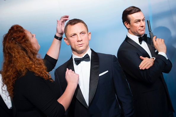 -Un employé ajuste les figures de cire des acteurs de James Bond Daniel Craig et Sean Connery où les ressemblances de cire des six acteurs de James Bond ont été présentées au musée de cire le 4 octobre 2016 à Berlin. Photo Steffi Loos / AFP via Getty Images.