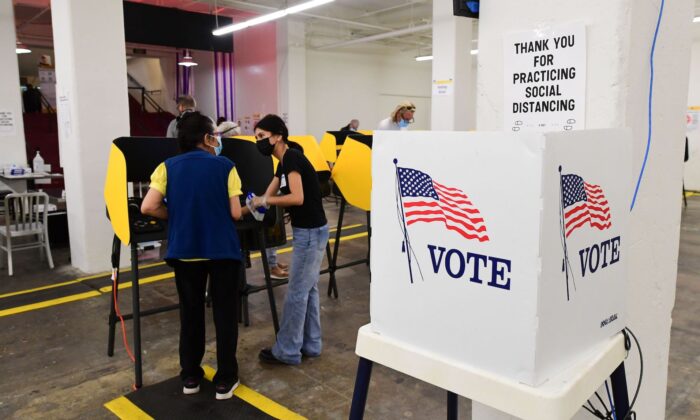 Un électeur reçoit l'aide d'un travailleur électoral dans un centre de vote à Grand Central Market à Los Angeles le 3 novembre 2020. (Frederic J. Brown/AFP via Getty Images)
