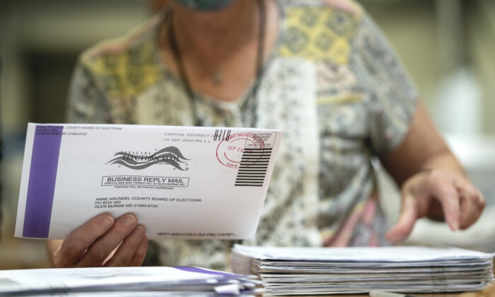 Un agent électoral  traite les bulletins de vote par correspondance dans un entrepôt au siège du conseil électoral du comté d'Anne Arundel à Glen Burnie, dans le Maryland, États-Unis, le 7 octobre 2020. (Drew Angerer/Getty Images)