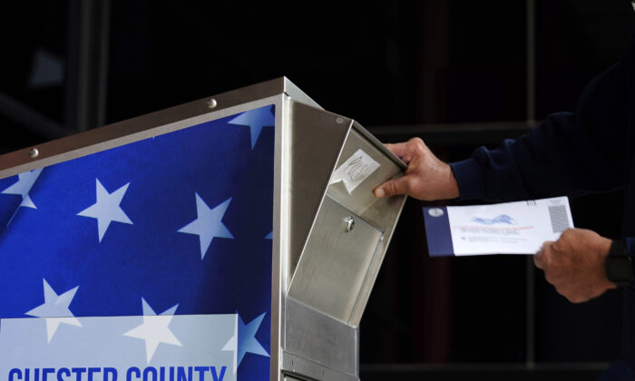 Un homme dépose son bulletin de vote pour les élections générales de 2020 aux États-Unis devant le centre des services gouvernementaux du comté de Chester, à West Chester (Pennsylvanie), le 23 octobre 2020. (Matt Slocum/AP Photo)