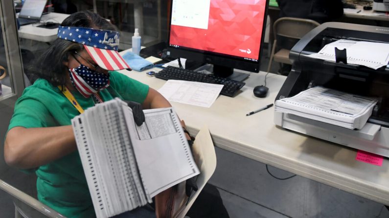Une employée du comté de Clark scrute les bulletins de vote postaux au département électoral du comté de Clark à North Las Vegas, Nevada, le 7 novembre 2020. (Ethan Miller/Getty Images)
