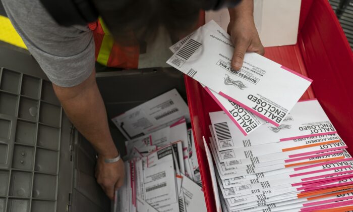Un travailleur électoral trie les bulletins de vote soumis au bureau électoral du comté de Multnomah, à Portland, en Oregon, le 2 novembre 2020. (Nathan Howard/Getty Images)
