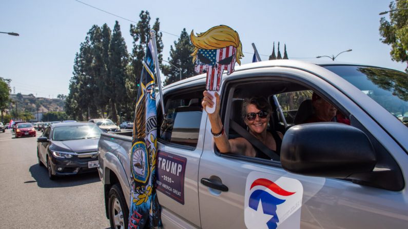 Une femme tient une pancarte pro-Trump au sein d'une caravane de voitures Pro-Trump à Long Beach, Californie, le 3 octobre 2020. (Apu Gomes AFP via Getty Images)