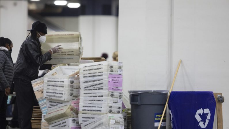 Un employé du département des élections de Détroit aide à empiler des boîtes vides utilisées pour organiser les votes par correspondance après la fin du comptage des votes par correspondance au local de dépouillement du centre TCF de Détroit, Michigan, le 4 novembre 2020. (Elaine Cromie/Getty Images)
