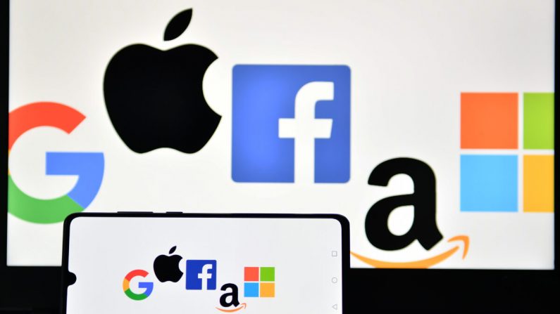 Une photo d'illustration prise à Londres le 18 décembre 2020 montre les logos de Google, Apple, Facebook, Amazon et Microsoft affichés sur un téléphone portable et sur l'écran d'un ordinateur portable. (Justin Tallis/AFP via Getty Images)

