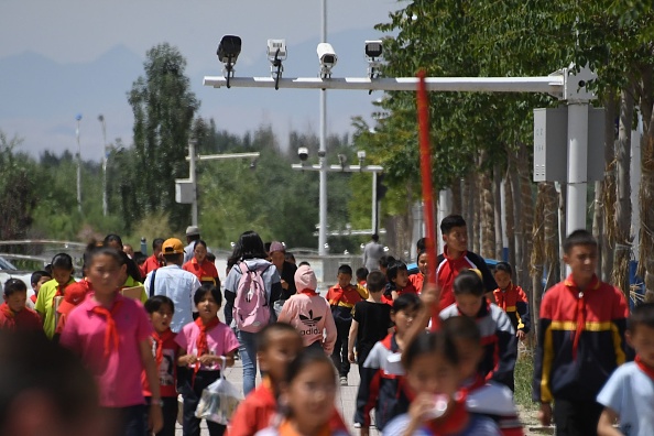 - Des écoliers marchent sous des caméras de surveillance, dans la région occidentale du Xinjiang en Chine, le 4 juin 2019. Photo Greg Baker / AFP via Getty Images.