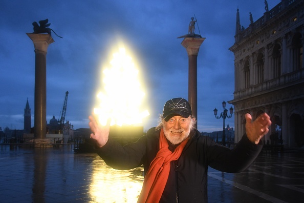 -L'artiste italien Fabrizio Plessi pose devant son installation lumineuse mise en place entre les colonnes de la place Saint-Marc le 4 décembre 2020 à Venise. Photo par Andrea Pattaro / AFP via Getty Images.