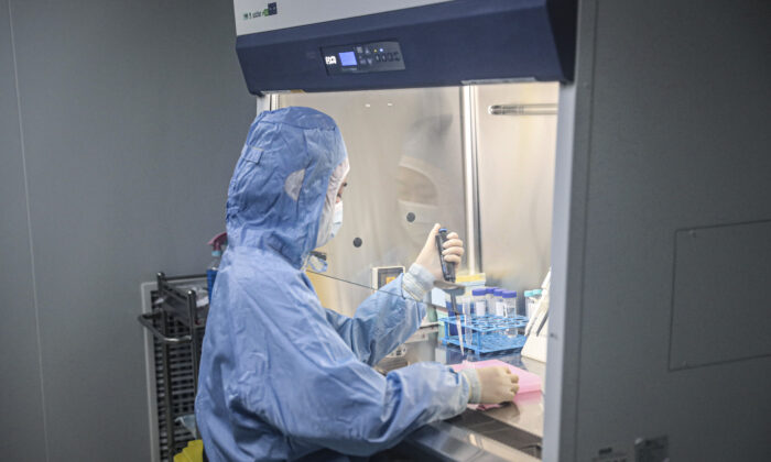 Un employé travaille sur des kits de détection du coronavirus Covid-19 dans un laboratoire de la société chinoise Biotech & Biomedicine Group à Shenyang, en Chine, le 14 décembre 2020. (STR/AFP via Getty Images)