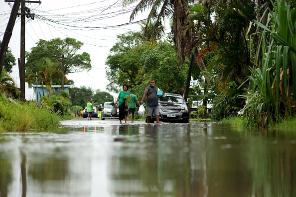 -Les résidents pataugent dans les rues inondées de Suva, la capitale des Fidji, le 16 décembre 2020, avant l’arrivée du super cyclone Yasa. Photo par Leon Lord / AFP via Getty Images.