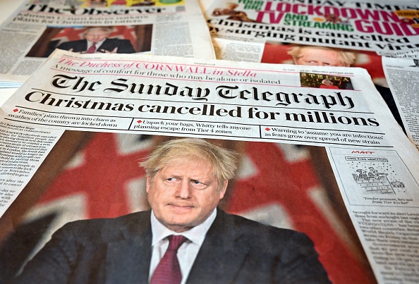 -Les gros titres de la première page relatent les nouvelles restrictions données par le Premier ministre britannique Boris Johnson, plus strictes contre le coronavirus COVID-19 pour Londres et le sud-est de l'Angleterre. Photo par Paul Ellis / AFP via Getty Images.