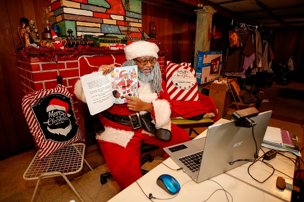 -André Russel habillé en Père Noël parle à son client lors d'un rendez-vous virtuel dans sa maison à Chicago, Illinois, le 17 décembre 2020. Photo par Kamil Krzaczynski / AFP via Getty Images.