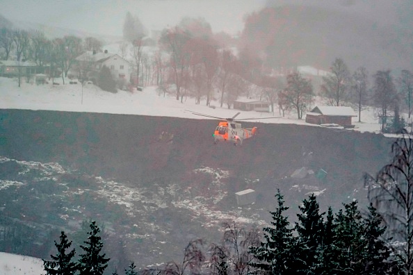 Un hélicoptère de sauvetage vole au-dessus des débris de maisons détruites par un glissement de terrain dans la ville d'Ask, dans le comté de Gjerdrum. (Photo : FREDRIK HAGEN/NTB/AFP via Getty Images)