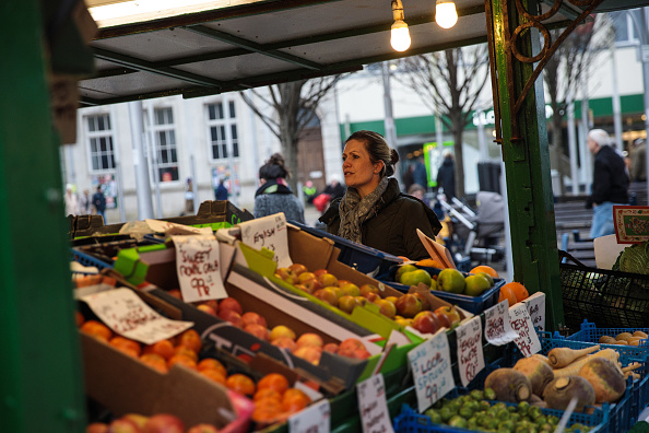 -Une femme achète des fruits à un étal de fruits et légumes à Great Yarmouth Market le 8 février 2017 Royaume-Uni. La ville de Great Yarmouth, a voté à 72% pour quitter l'Union européenne lors du référendum du 23 juin 2016. Photo de Jack Taylor / Getty Images.