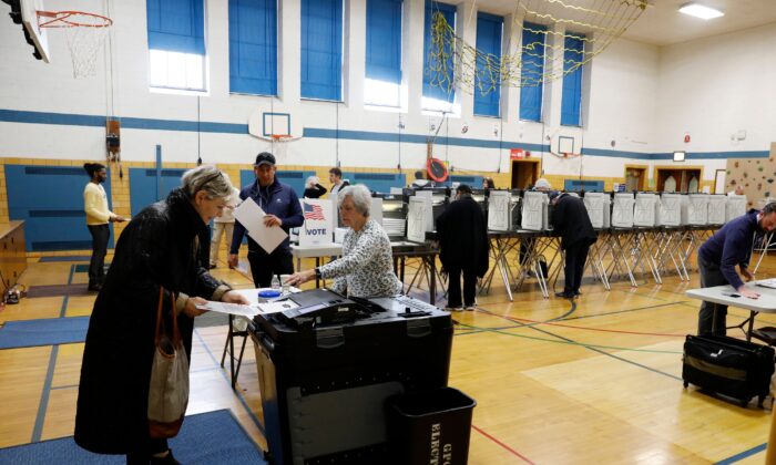 Des gens mettent des bulletins de vote dans une machine de dépouillement à Grosse Pointe, Michigan, dans un dossier photographique du 10 mars 2020. (Jeff Kowalsky/AFP via Getty Images)