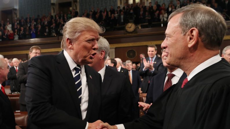 Le président Donald Trump (à gauche) serre la main du juge en chef John Roberts (à droite) dans la salle des séances de la Chambre des représentants du Capitole américain le 28 février 2017. (Jim Lo Scalzo - Pool/Getty Images)