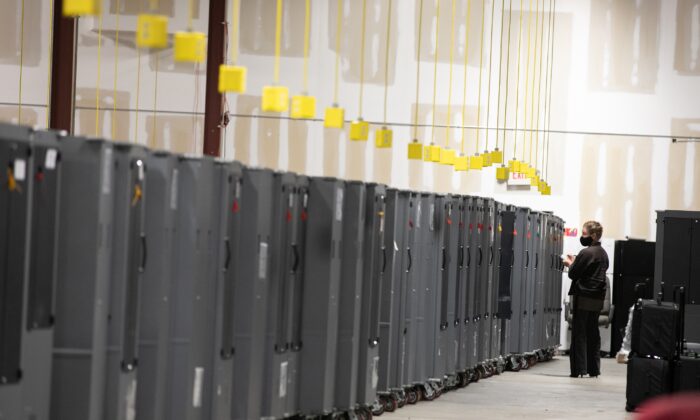 Un observateur du scrutin du Parti républicain géorgien observe les systèmes de transport de machines à voter entreposés au centre de préparation des élections du comté de Fulton, à Atlanta, en Georgie, le 4 novembre 2020. (Jessica McGowan/Getty Images)