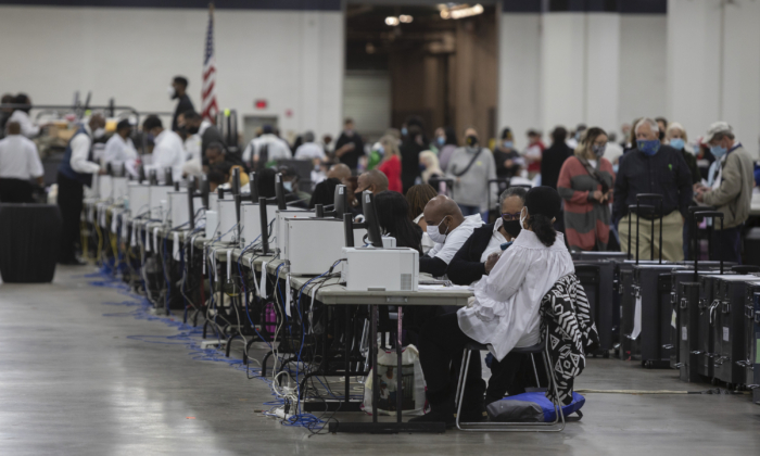 Des employés du service des élections de Detroit aident à traiter les bulletins de vote par correspondance au Central Counting Board du centre TCF de Detroit, Michigan, le 4 novembre 2020. (Elaine Cromie/Getty Images)