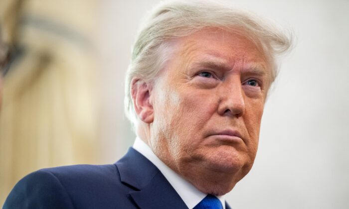 Le président américain Donald Trump assiste à la cérémonie de remise de la médaille présidentielle de la liberté au lutteur Dan Gable dans le bureau ovale de la Maison-Blanche à Washington, le 7 décembre 2020. (Saul Loeb/AFP via Getty Images)