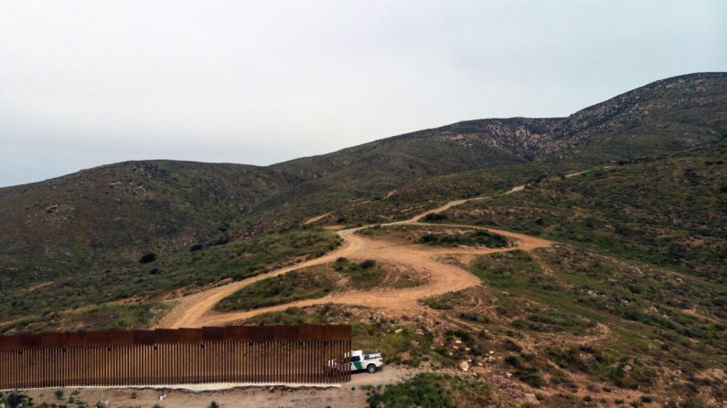 Un véhicule de patrouille frontalière est garé à côté d'une section de la clôture de la frontière entre les États-Unis et le Mexique qui se termine à El Nido de las Aguilas, en Basse Californie, le 26 mars 2019. (Guillermo Arias/AFP via Getty Images)