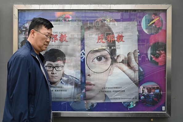 -Un homme passe devant des affiches du Falun Gong à côté d'un trottoir à Pékin le 23 avril 2019. Photo Greg Baker /AFP via Getty Images.