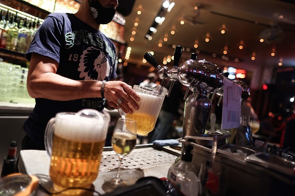 -Un serveur sert des bières dans un bar à la veille de la fermeture obligatoire des bars à Bruxelles, le 7 octobre 2020. Photo par Kenzo Tribouillard / AFP via Getty Images.