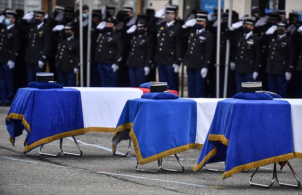 Les cercueils des trois gendarmes tués la semaine dernière par un homme armé à Saint-Just sont exposés lors d'une cérémonie d'hommage, le 28 décembre 2020 à Ambert. (PHILIPPE DESMAZES/POOL/AFP via Getty Images)