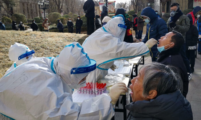 Le 6 janvier 2021, des travailleurs de la santé prélèvent des échantillons par écouvillonnage sur les habitants de Shijiazhuang, dans la province de Hebei, en Chine. (STR/CNS/AFP via Getty Images)
