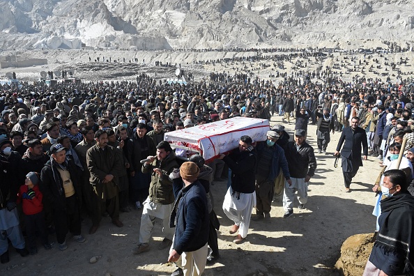 -Des personnes en deuil de la communauté chiite Hazara portent le cercueil de l'un des mineurs, qui a été tué lors d'une attaque, une procession funéraire dans un cimetière de Quetta le 9 janvier 2021. Photo de Banaras Khan / AFP via Getty Images.