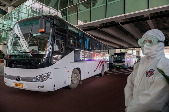 -Un bus transportant des membres de l'équipe de l'Organisation mondiale de la santé quitte l'aéroport après leur arrivée, Wuhan le 14 janvier 2021. Photo de Nicolas Asfouri / AFP via Getty Images.