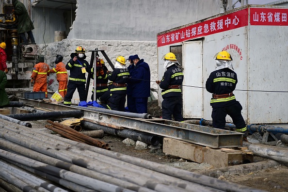 -Une équipe de secours travaille sur le site d'une mine d'or où 22 mineurs sont piégés sous terre à Qixia, dans l'est de la Chine. Photo de STR / AFP via Getty Images.