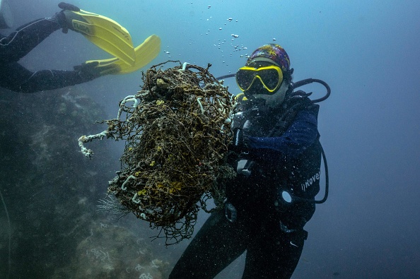 -Des plongeurs sous-marins dans des eaux obstruées par du plastique au large des côtes thaïlandaises, le 20 décembre 2020. Photo Lillian Suwanrumpha / AFP via Getty Images. 