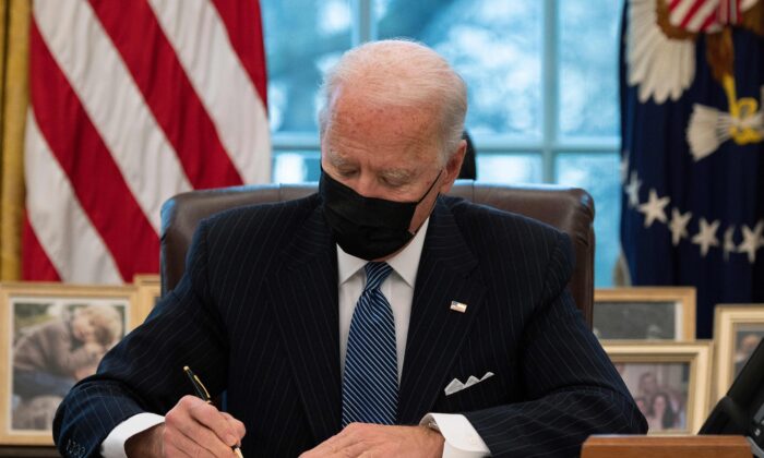 Le président Joe Biden signe un décret annulant l'interdiction de l'ère Trump pour les transgenres dans l'armée, dans le bureau ovale de la Maison-Blanche le 25 janvier 2021. (Jim Watson/AFP via Getty Images)