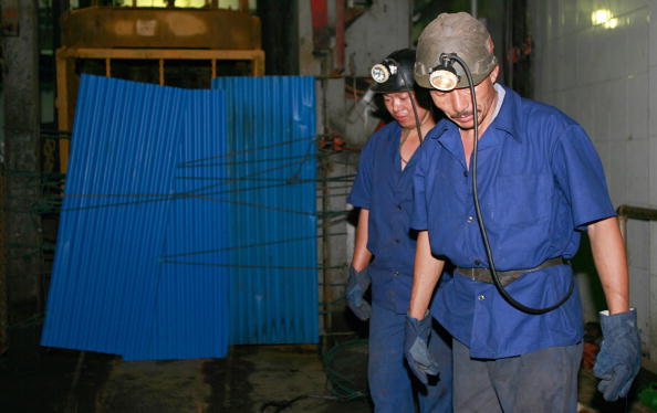 -Illustration- Des mineurs chinois sont vus près d'une ouverture de mine et participent à l'opération de sauvetage dans l'est de la province du Shandong. Photo Teh Eng Koon / AFP via Getty Images.
