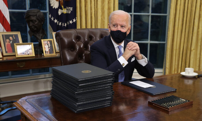 Le président Joe Biden se prépare à signer une série de décrets au Resolute Desk dans le Bureau ovale quelques heures après son investiture à Washington le 20 janvier 2021. (Chip Somodevilla/Getty Images)