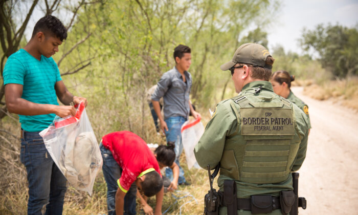 Les agents de la patrouille frontalière demandent aux étrangers d'enlever leurs lacets et leurs affaires avant de les charger dans un fourgon pour les transporter dans le comté de Hidalgo, au Texas, le 26 mai 2017. (Benjamin Chasteen/Epoch Times)