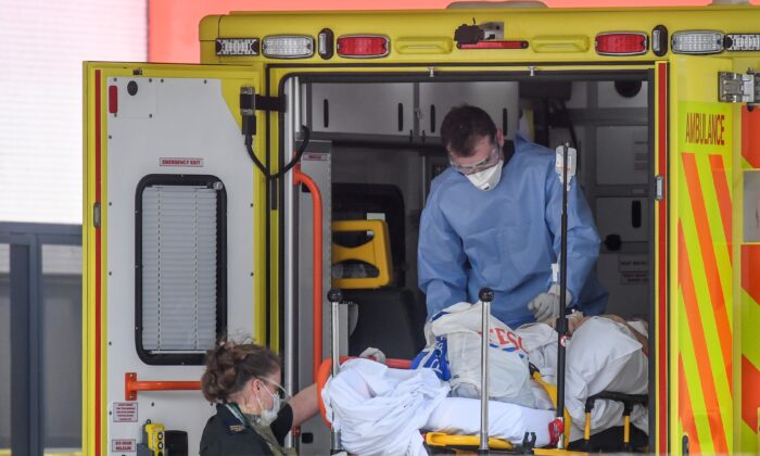 Un médecin portant un équipement de protection en train de transférer un patient devant l'hôpital St Thomas, à Londres, le 7 avril 2020. (Peter Summers/Getty Images)