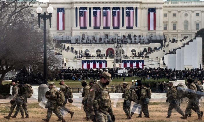 Des soldats de la Garde nationale portent des boucliers antiémeutes alors qu'ils prennent position à proximité du Capitole américain lors de l'inauguration de Joe Biden à Washington, le 20 janvier 2021. (Roberto Schmidt/AFP via Getty Images)