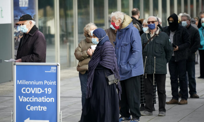 Le 11 janvier 2021, les gens font la queue devant le centre de vaccination de masse du NHS qui a été mis en place au centre Millennium Point de Birmingham, au Royaume-Uni. (Christopher Furlong/Getty Images)