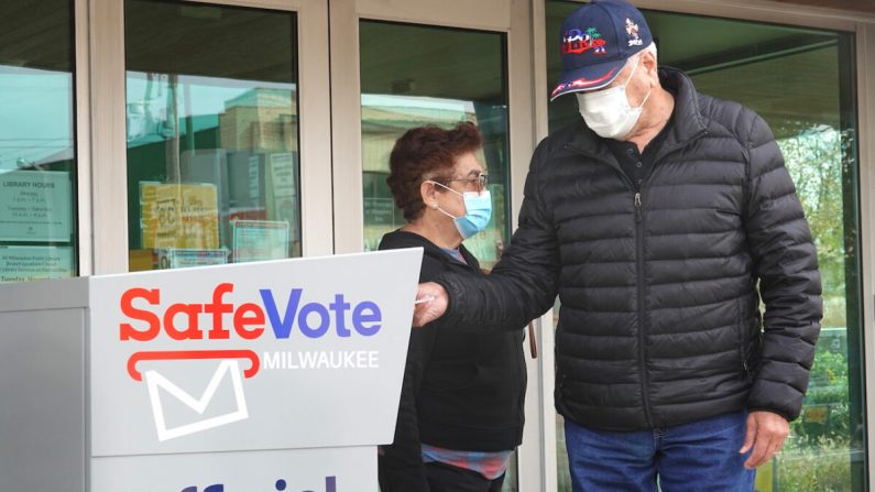 Des résidents déposent des bulletins de vote par correspondance dans une urne devant la bibliothèque de la succursale de Tippecanoe à Milwaukee, Wisconsin, le 20 octobre 2020. (Scott Olson/Getty Images)

