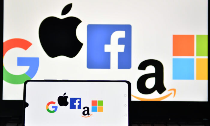 Les logos de Google, Apple, Facebook, Amazon et Microsoft sont affichés sur un téléphone portable et un écran d'ordinateur portable à Londres le 18 décembre 2020. (Justin Tallis/AFP via Getty Images)