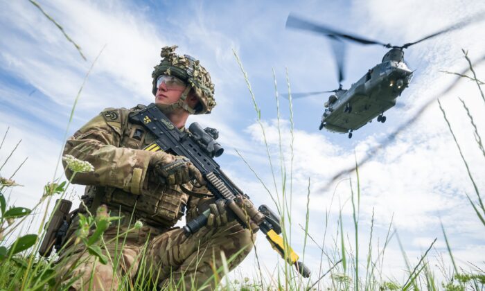 Le soldat Patrick Rodgers, du 2e bataillon du régiment britannique Anglian, assure la sécurité du périmètre alors qu'un hélicoptère Chinook effectue une évacuation médicale lors d'un exercice militaire sur les plaines de Salisbury, près de Warminster, en Angleterre, le 23 juillet 2020. (Leon Neal/Getty Images)
