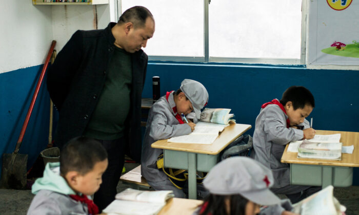 Un enseignant surveillant les élèves de l'école primaire Yang Dezhi "Armée rouge" à Wenshui, dans le comté de Xishui, dans la province de Guizhou, en Chine, le 7 novembre 2016. (FRED DUFOUR/AFP via Getty Images)