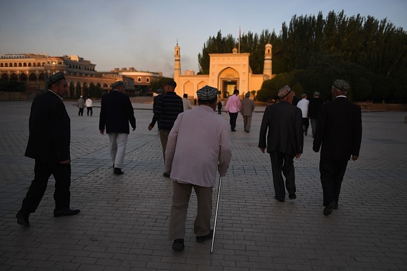 -Des hommes ouïghours marchent vers la mosquée Id Kah au Xinjiang en Chine, le 5 juin 2019. Photo par Greg Baker / AFP via Getty Images.