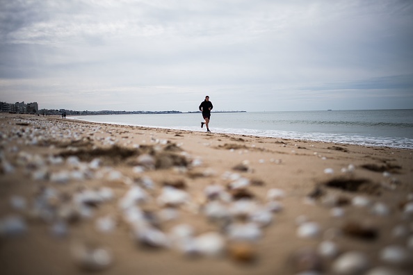 Un homme fait son jogging sur la plage de La Baule, dans l'ouest de la France. (LOIC VENANCE/AFP via Getty Images)
